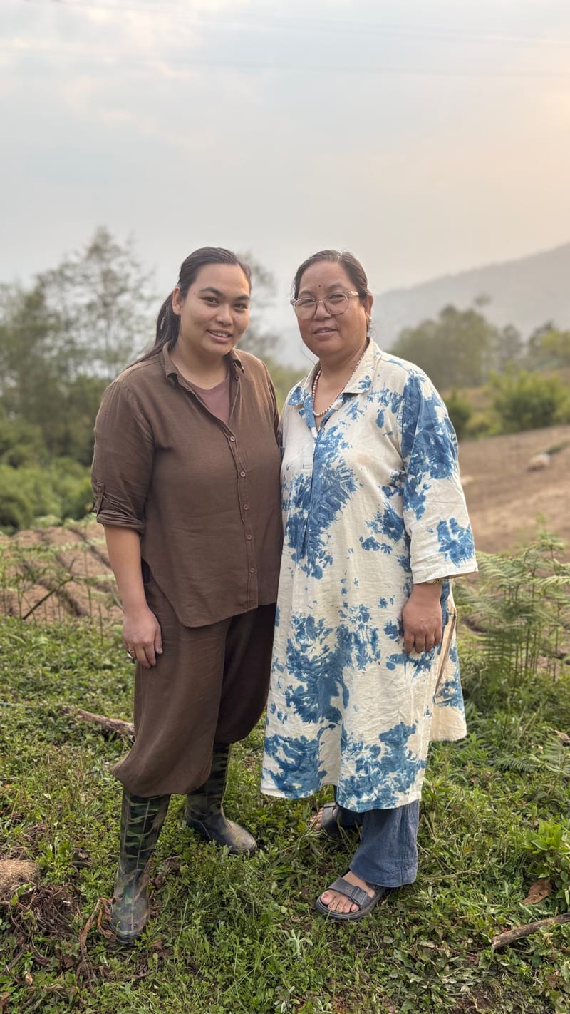 two women standing on a hillside in nepal