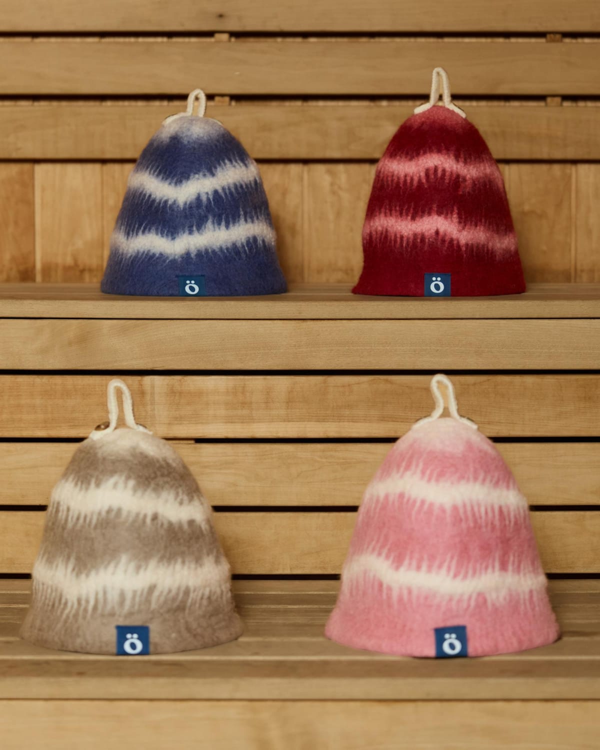 four löyl bloom hats waiting on the wooden benches of a sauna